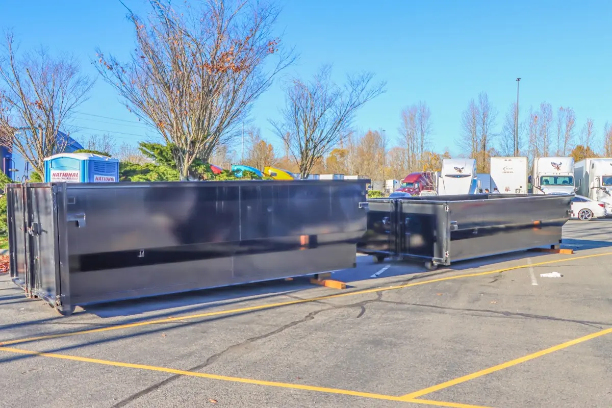 Professional dumpster rental service with roll-off container on residential driveway in Dudley